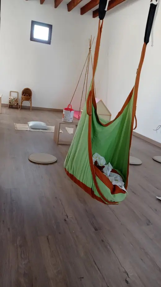 Hamaca colgante verde en un rincón de la sala